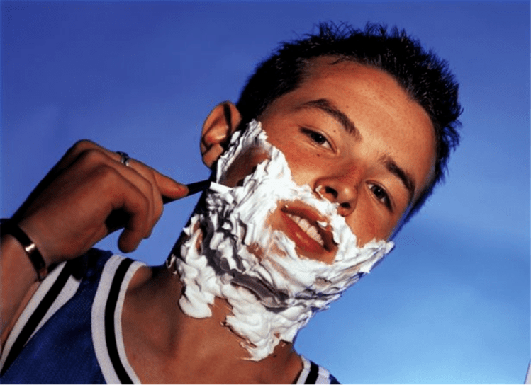 un adolescente afeita e pensa na ampliación do pene